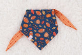 footballs and pumpkins on a navy blue background Pet bandana orange and navy for fall.